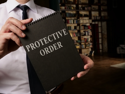 Lawyer shows book about Protective Order rules.