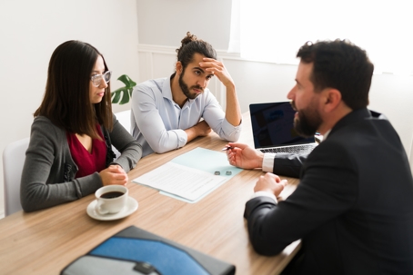 couple in a serious discussion with a lawyer