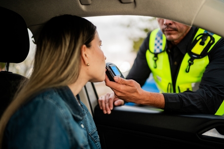 woman undergoing breathalyzer test